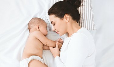 Schlafendes Baby neben schlafender Frau